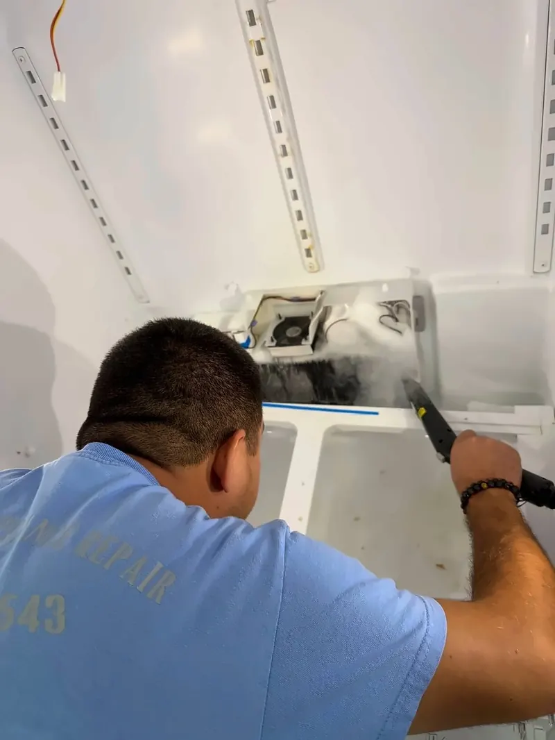 A technician clearing ice buildup inside a freezer